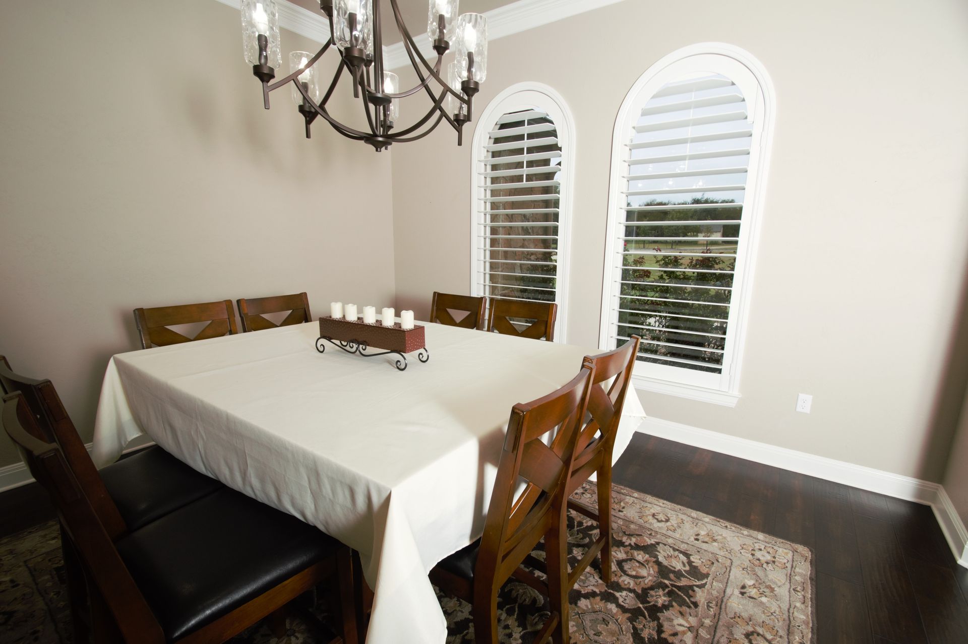 A dining room with a table and chairs and a chandelier.