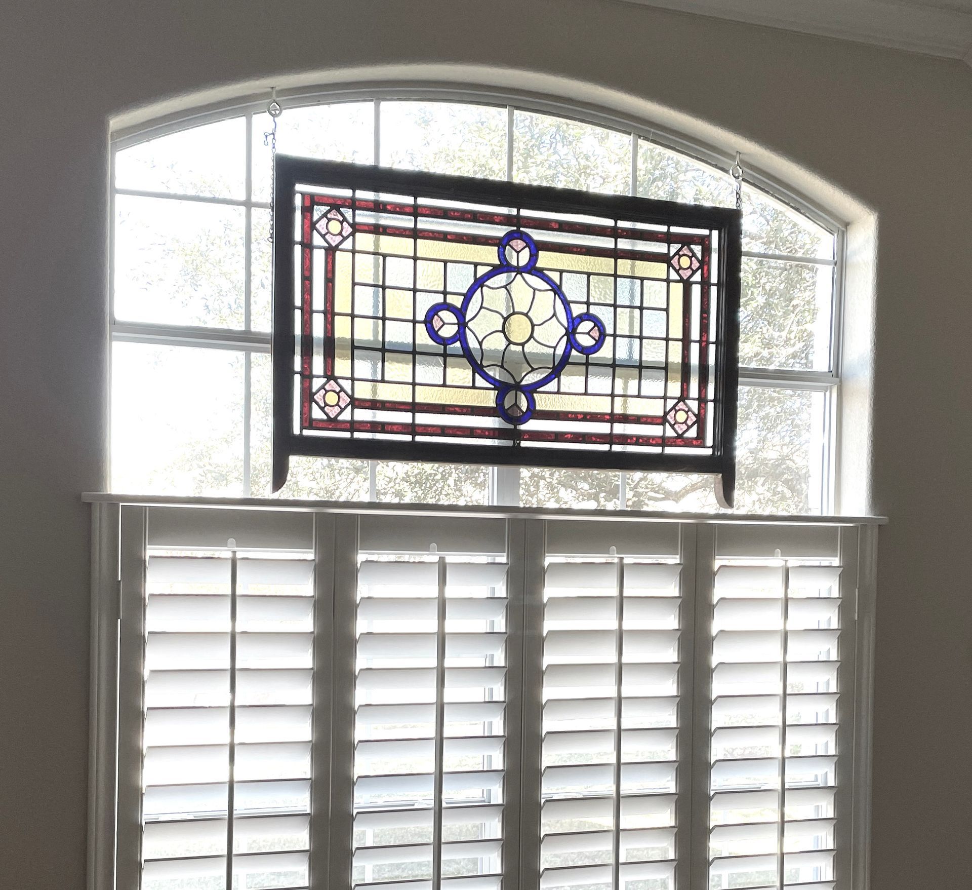 cafe style shutters covered stained glass window in Round Rock home