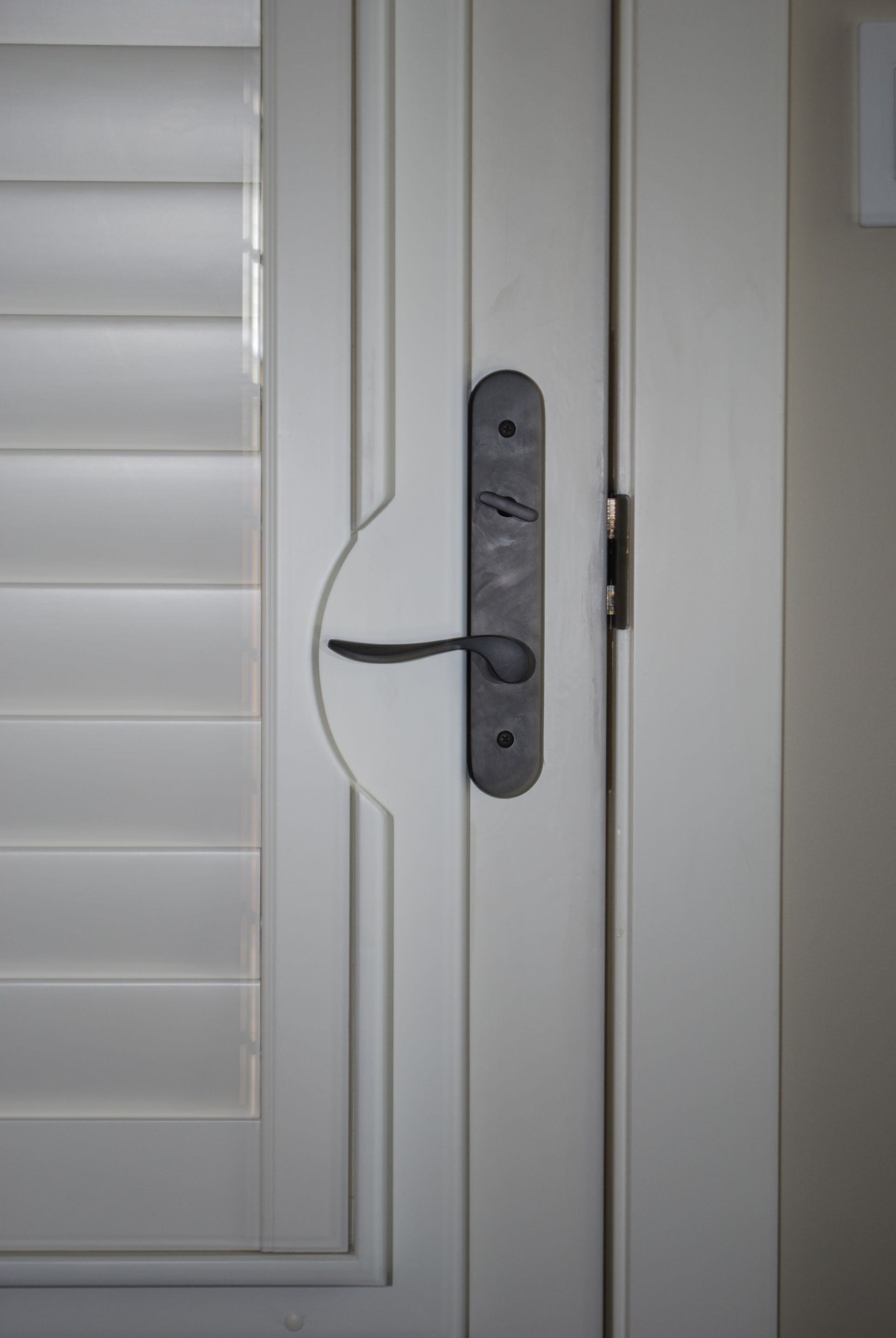 Cutout around door handle of plantation shutter installed on an interior door
