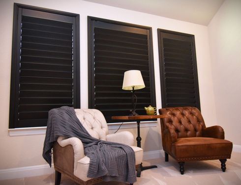 Closed black wooden shutters in traditional living room 
