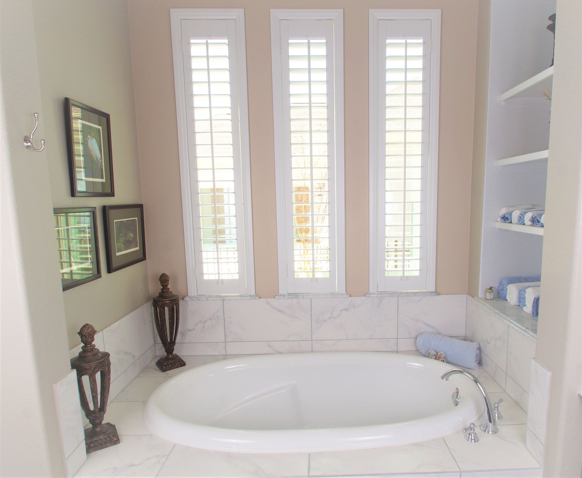 Row of three narrow bathroom windows covered by custom plantation shutters