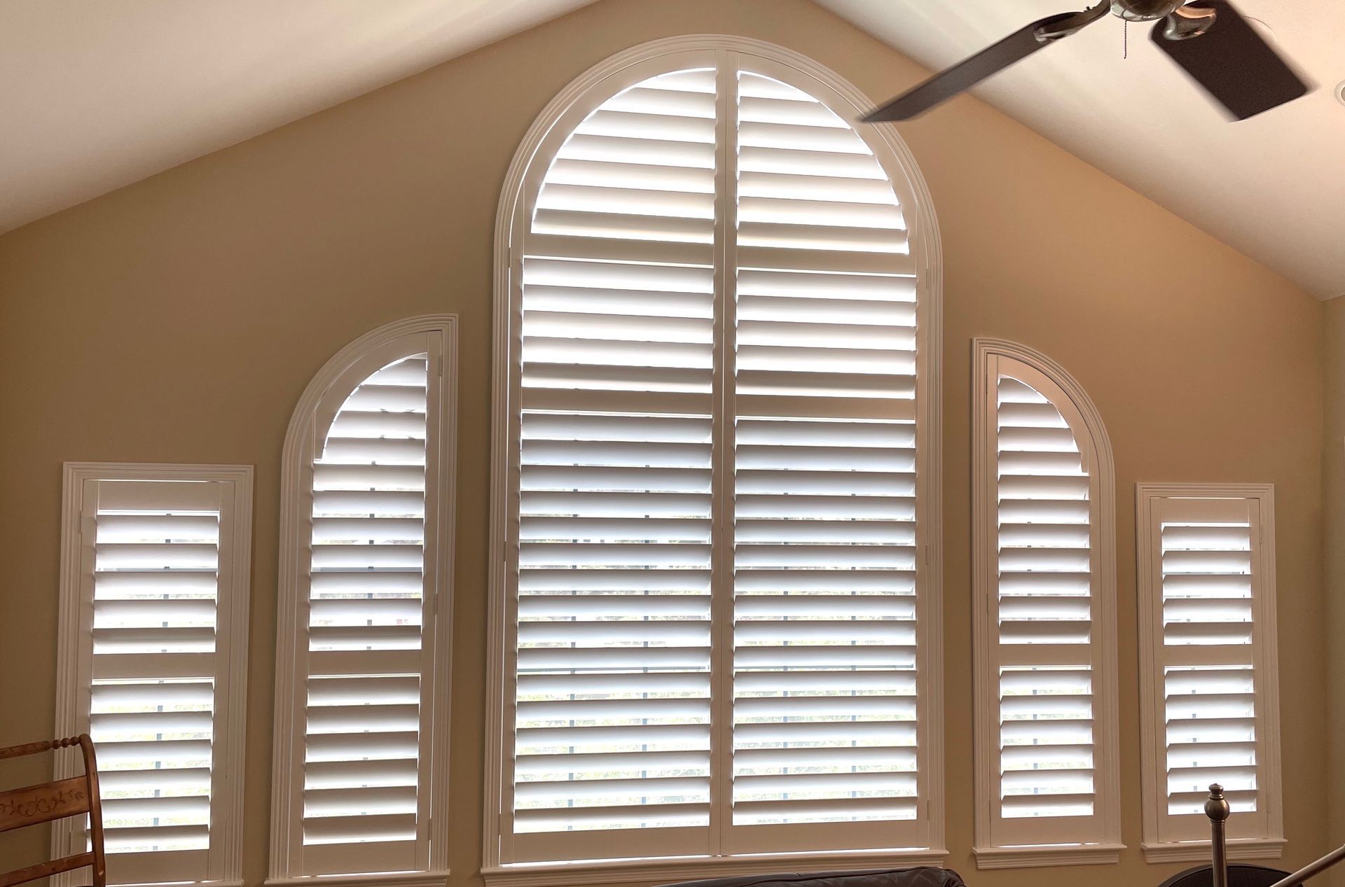 Plantation shutters cover large window in Round Rock home