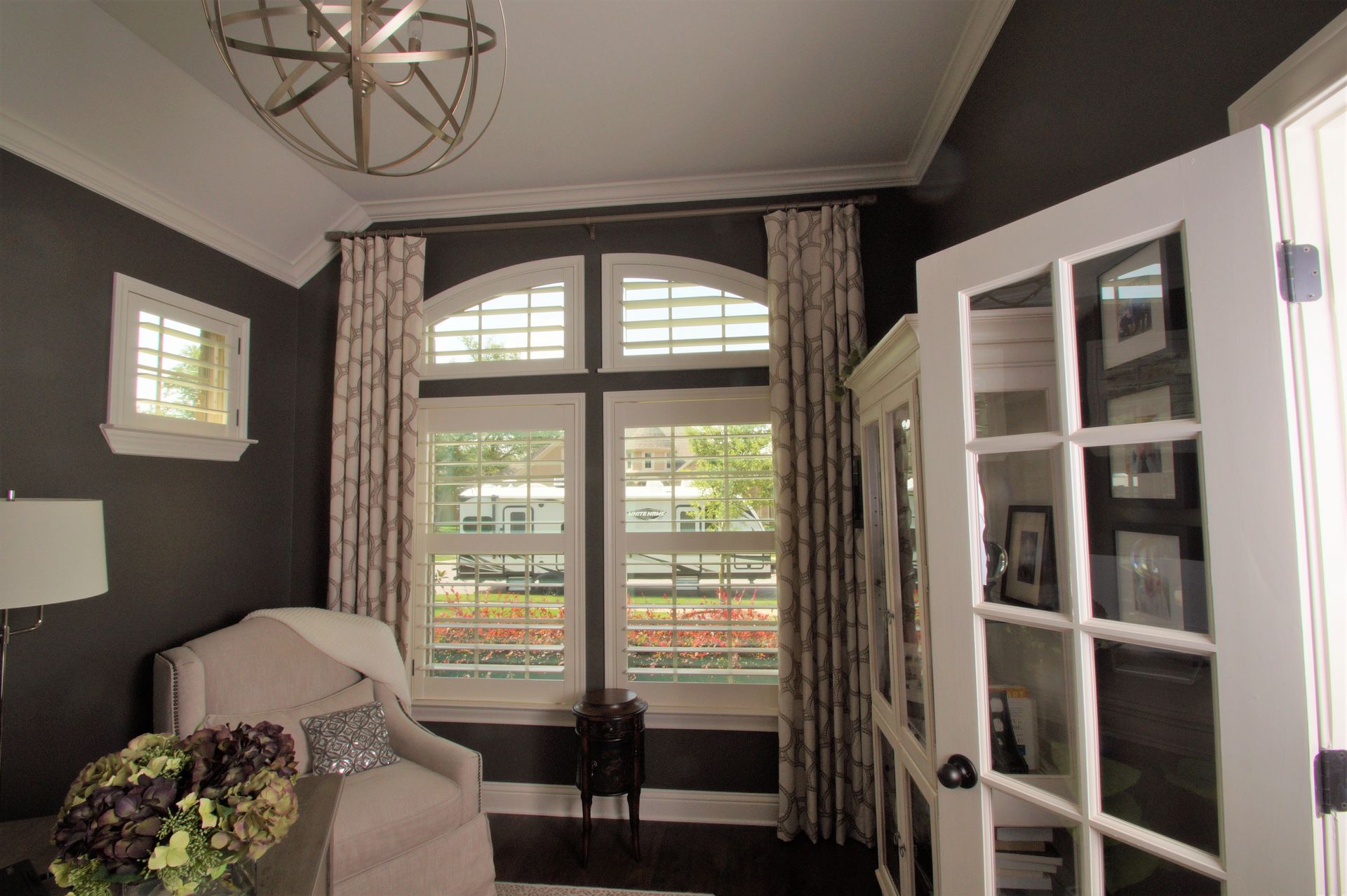 A living room with a lot of windows and a chandelier