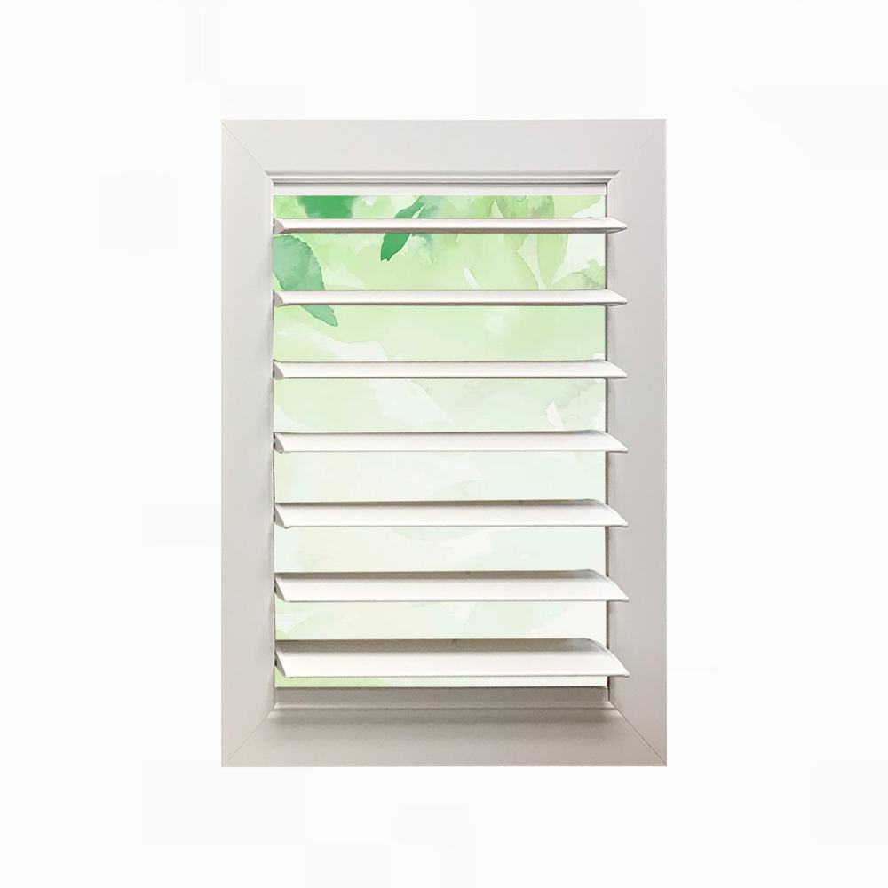 A window with shutters on it and a picture of leaves coming out of it.