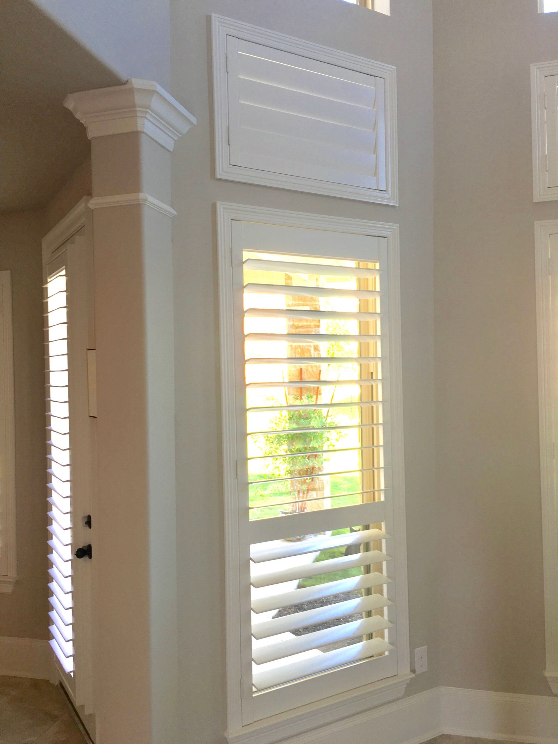 Small window covered by white plantation shutters in Leander home