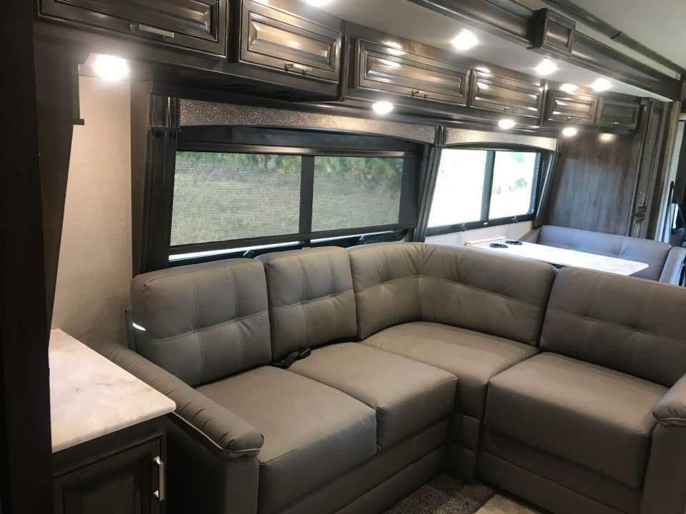 A living room in a rv with a couch and a table.
