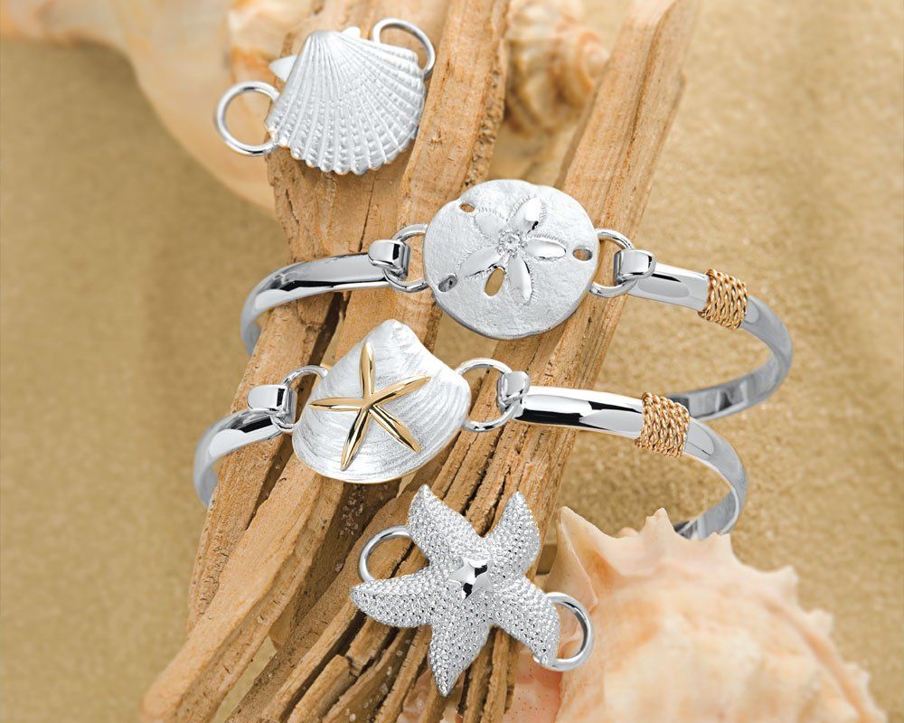 Silver bracelets in the shape of sand dollars, shells, and starfish