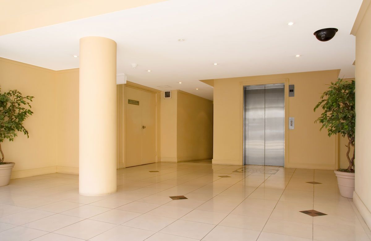 A hallway with a stainless steel elevator in the middle