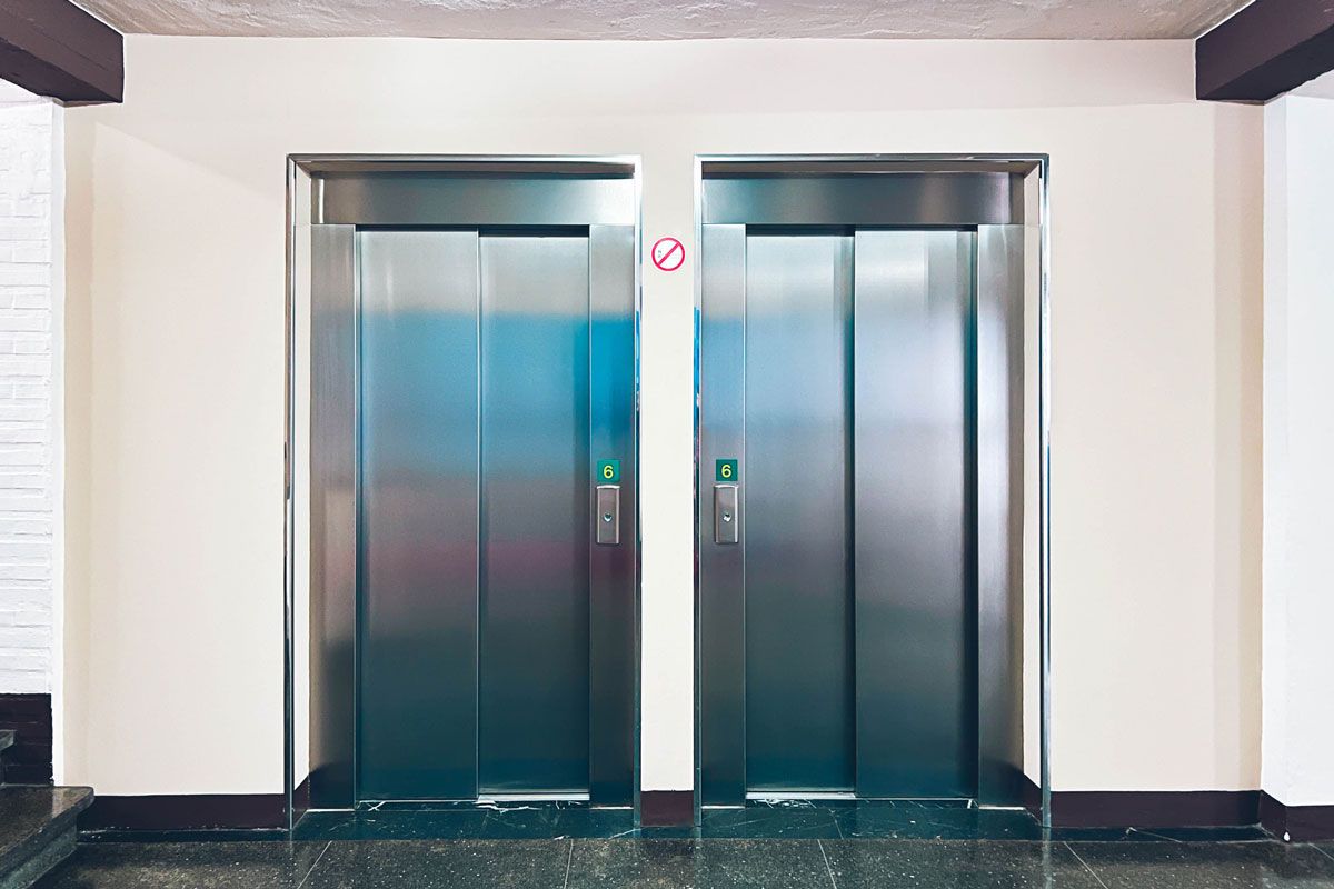 There are two elevators in the hallway of a building.