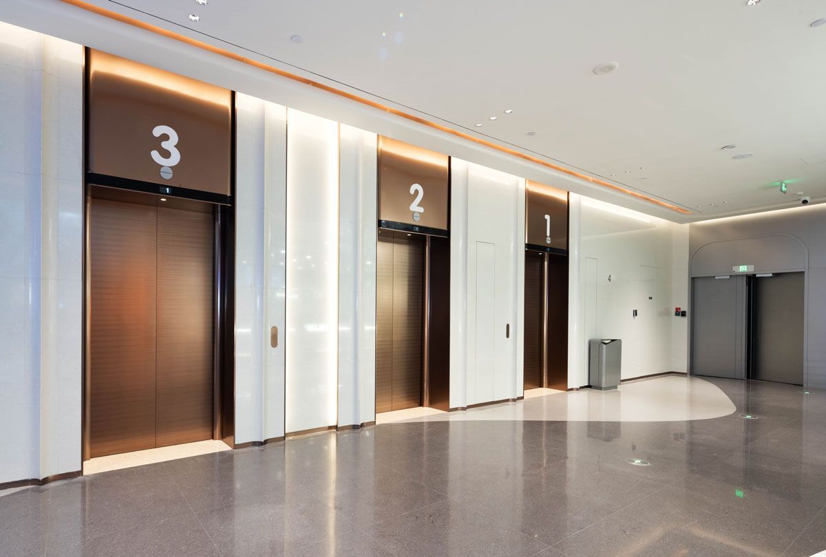 A row of elevators in a building with numbers on the doors.