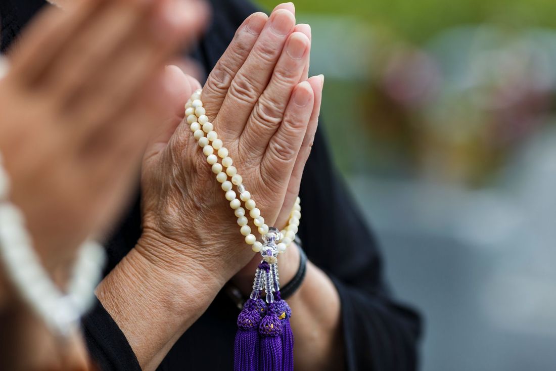 Mani a preghiera durante un funerale religioso