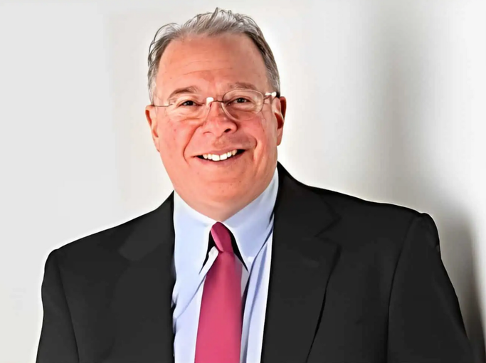 A man in a suit and tie is smiling for the camera.