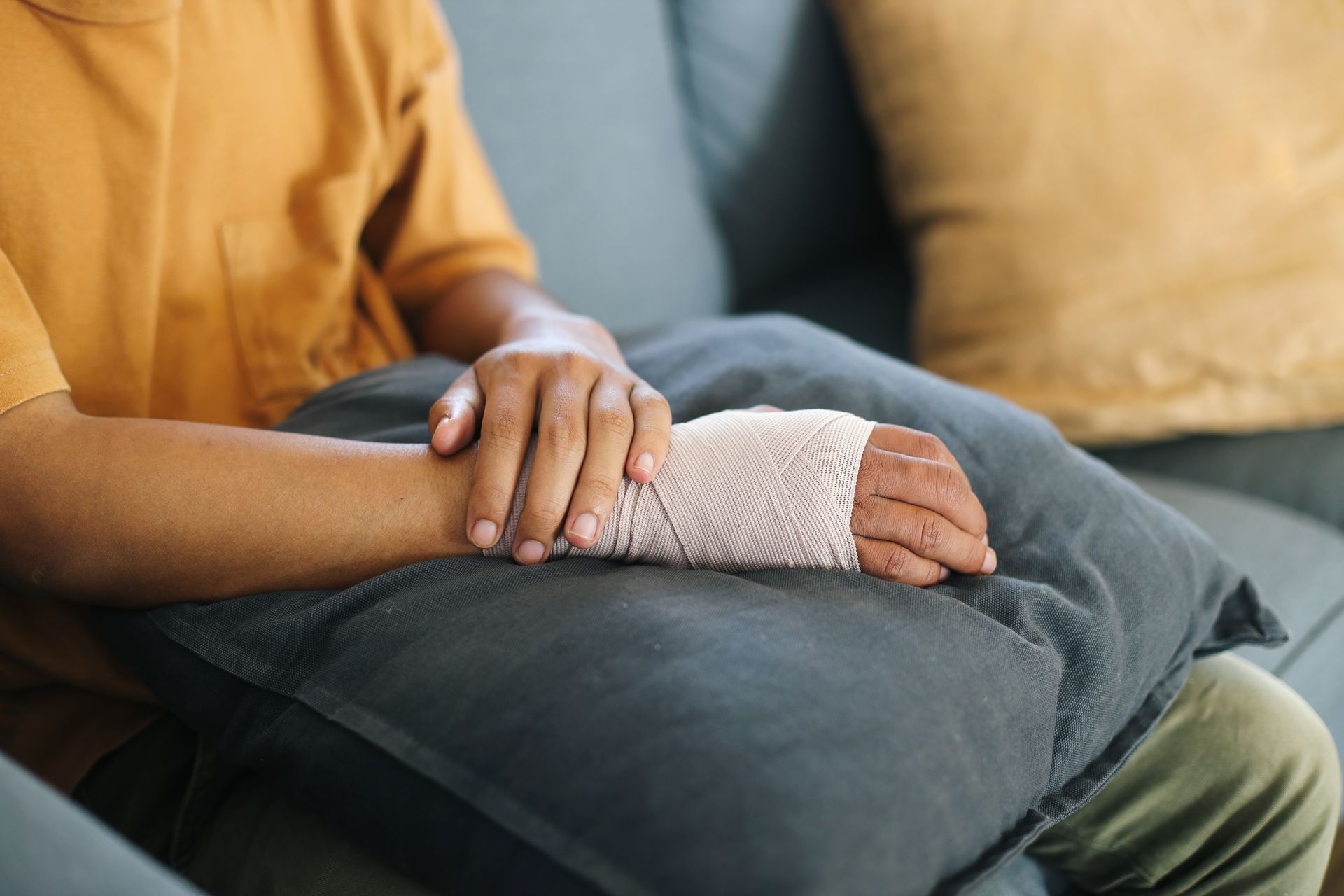 A person with a cast on their arm is sitting on a couch.