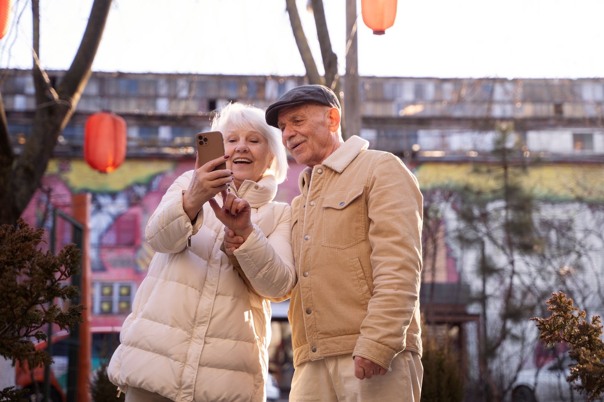 An elderly couple is taking a selfie with a cell phone.