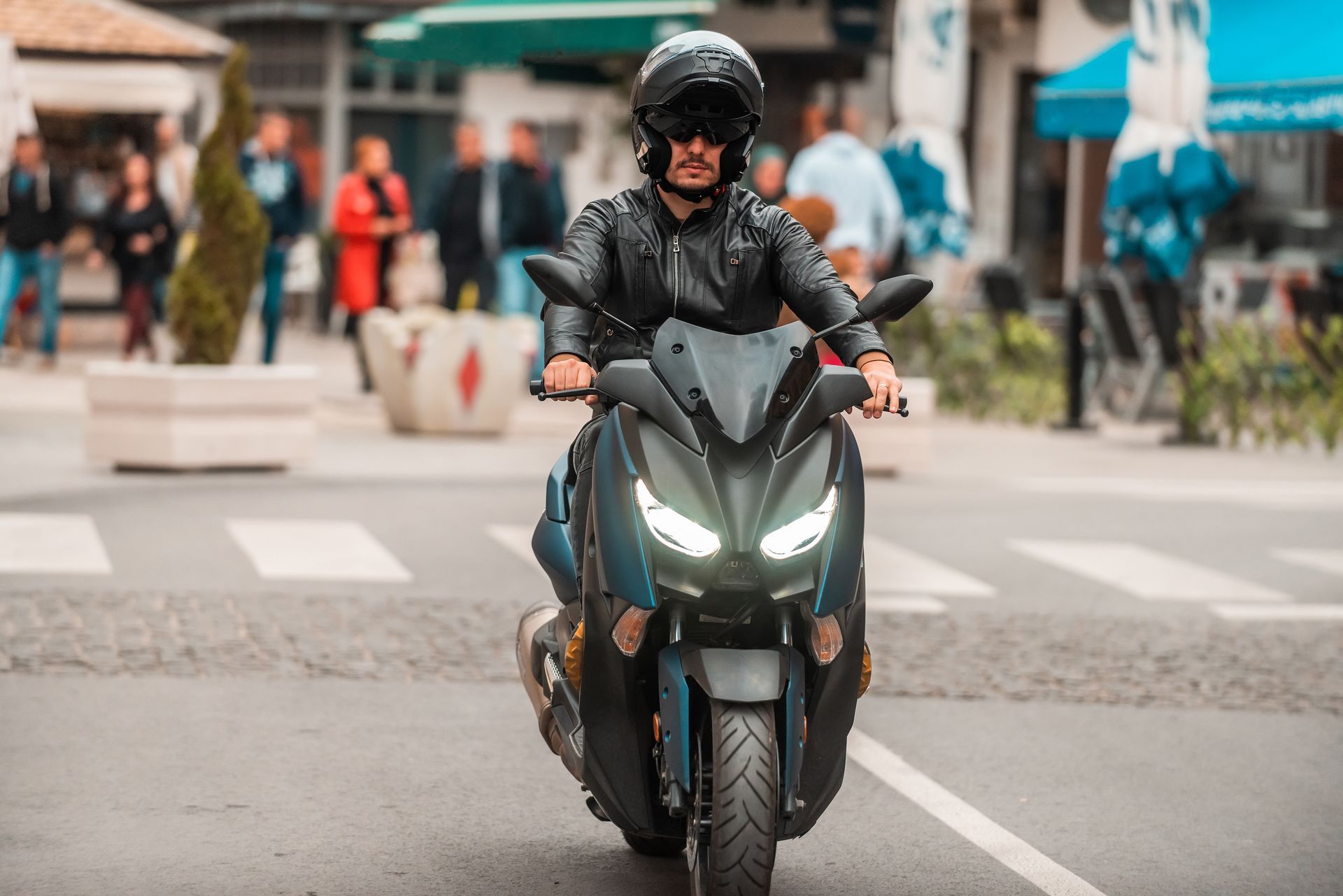 A man is riding a motorcycle down a city street.