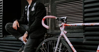 A man is sitting on a bicycle in front of a building.