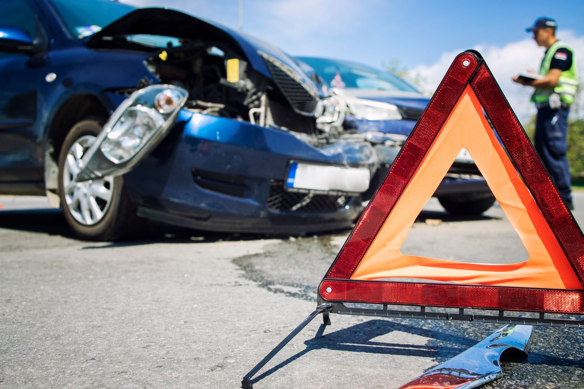 A car accident with a warning triangle in front of it.