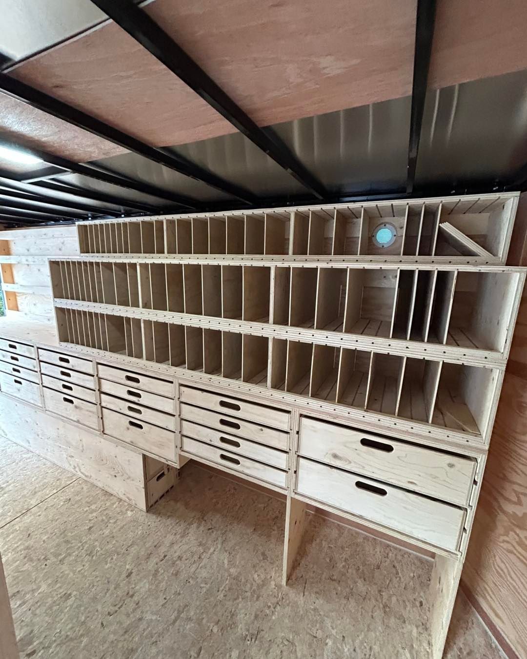 Étagères de rangement en bois avec tiroirs à l'intérieur d'une remorque.