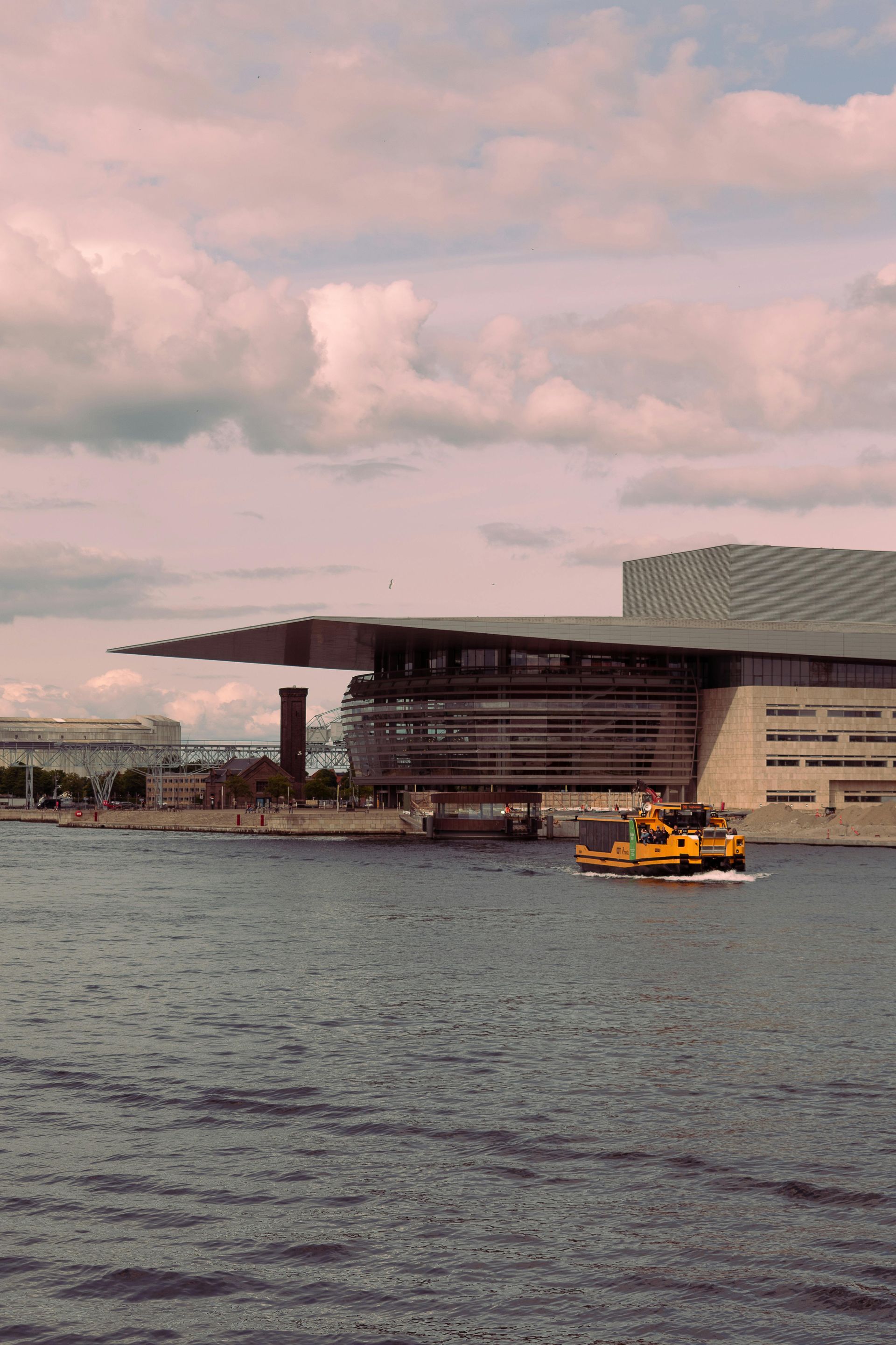 A boat is floating in the water near a large building