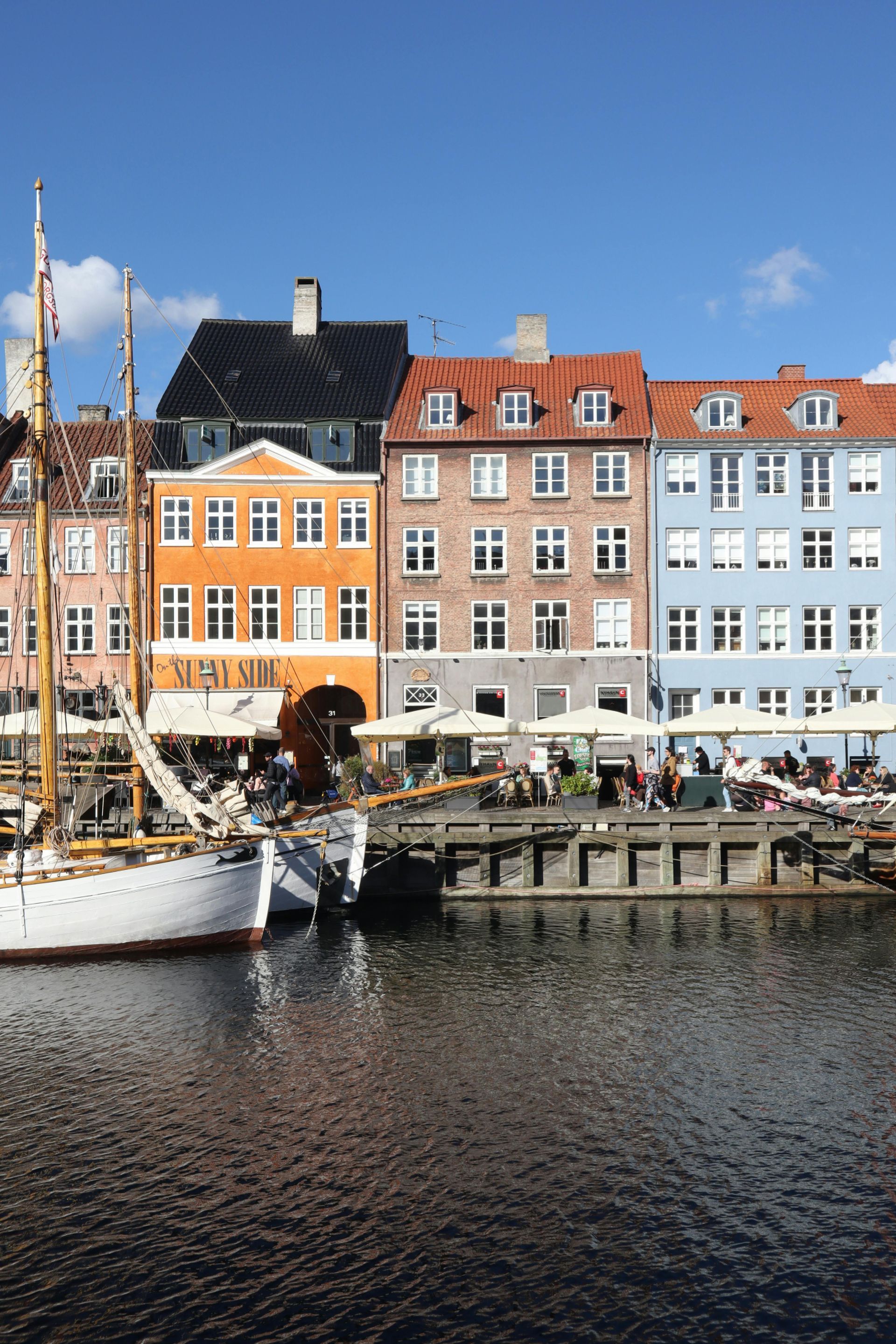 A boat is docked in front of a row of buildings