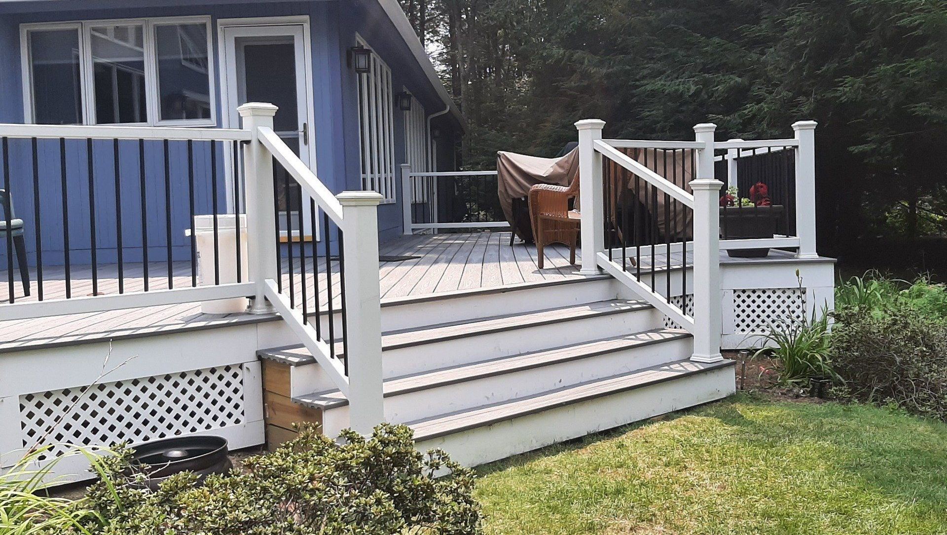 A blue house with a white deck and stairs - Plaistow, NH - Dynamic Deck Solutions