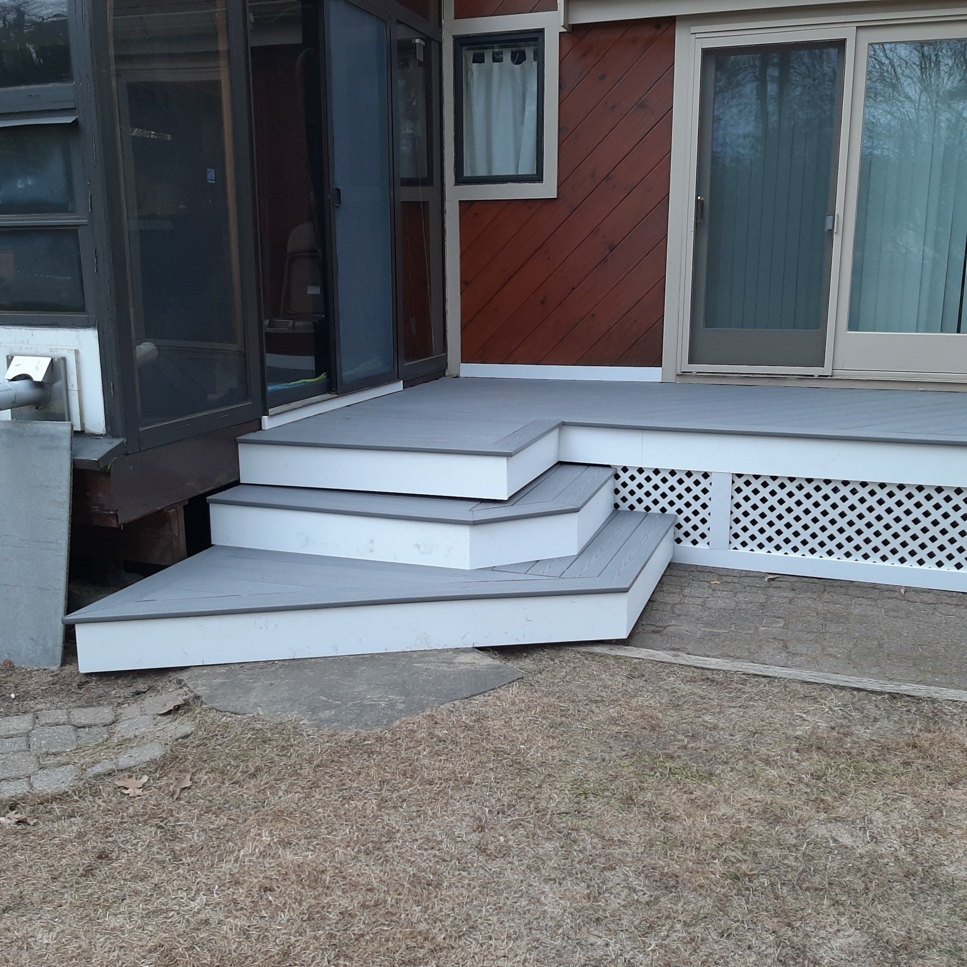 A porch with white steps and a screen door - Plaistow, NH - Dynamic Deck Solutions