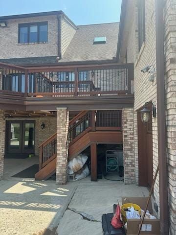 A large brick house with a wooden deck and stairs - Plaistow, NH - Dynamic Deck Solutions