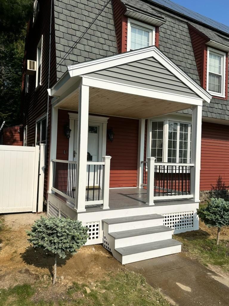 A red house with a white porch and stairs - Plaistow, NH - Dynamic Deck Solutions