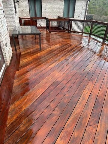 A wooden deck with a table and chairs on it - Plaistow, NH - Dynamic Deck Solutions