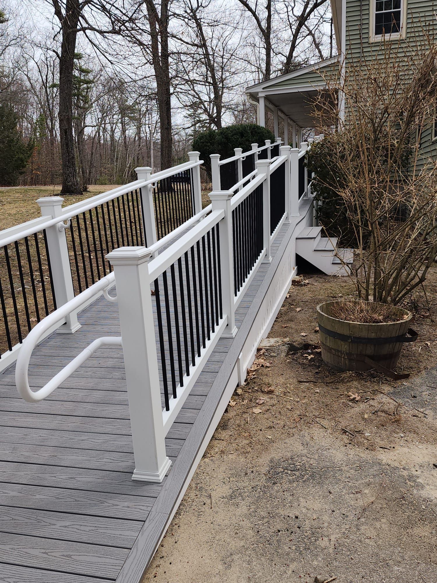 A wheelchair ramp leading to a house with a white railing - Plaistow, NH - Dynamic Deck Solutions