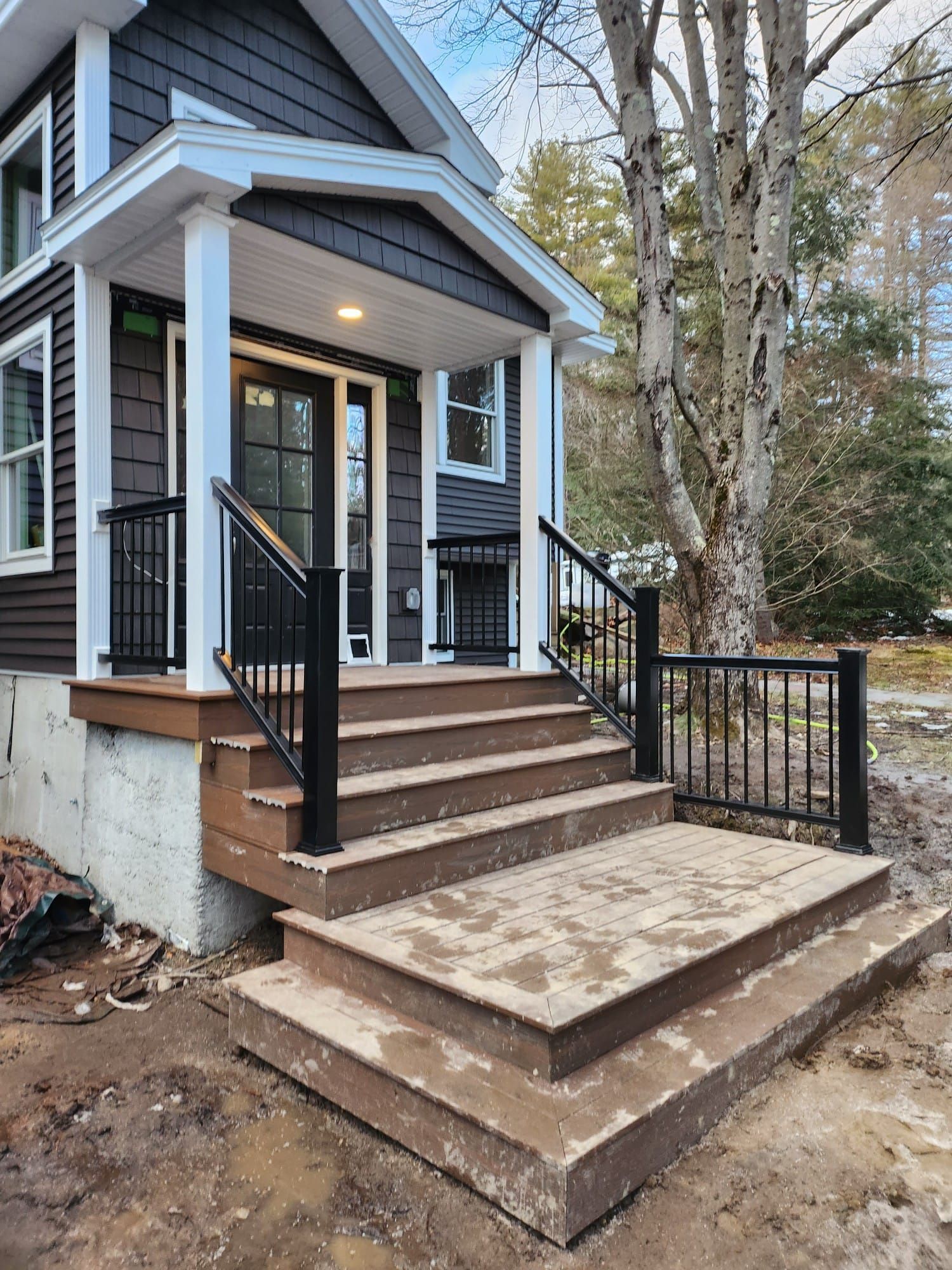 A house with a porch and stairs leading up to it - Plaistow, NH - Dynamic Deck Solutions
