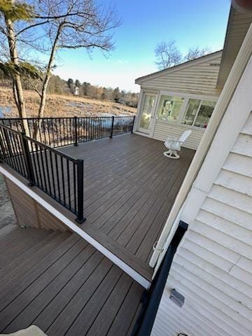 A large wooden deck with a black railing and a rocking chair on it - Plaistow, NH - Dynamic Deck Solutions