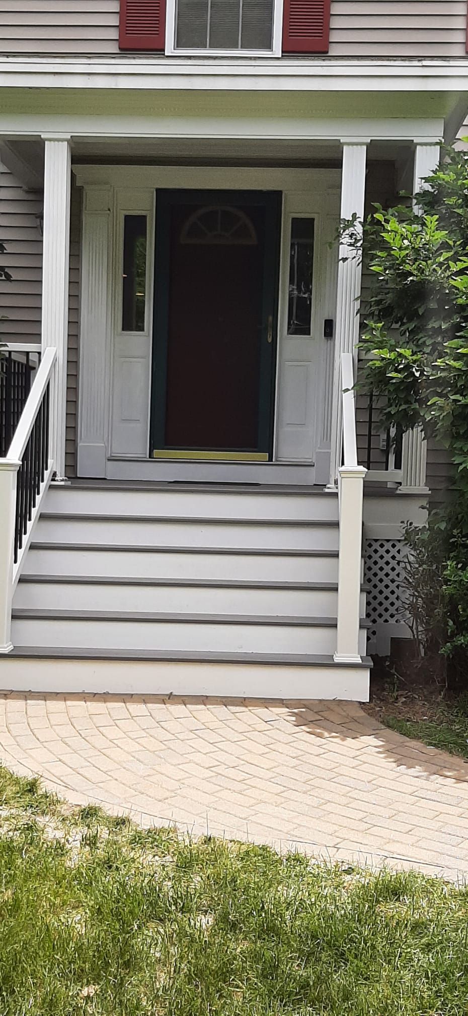 A house with a porch and stairs leading to the front door - Plaistow, NH - Dynamic Deck Solutions