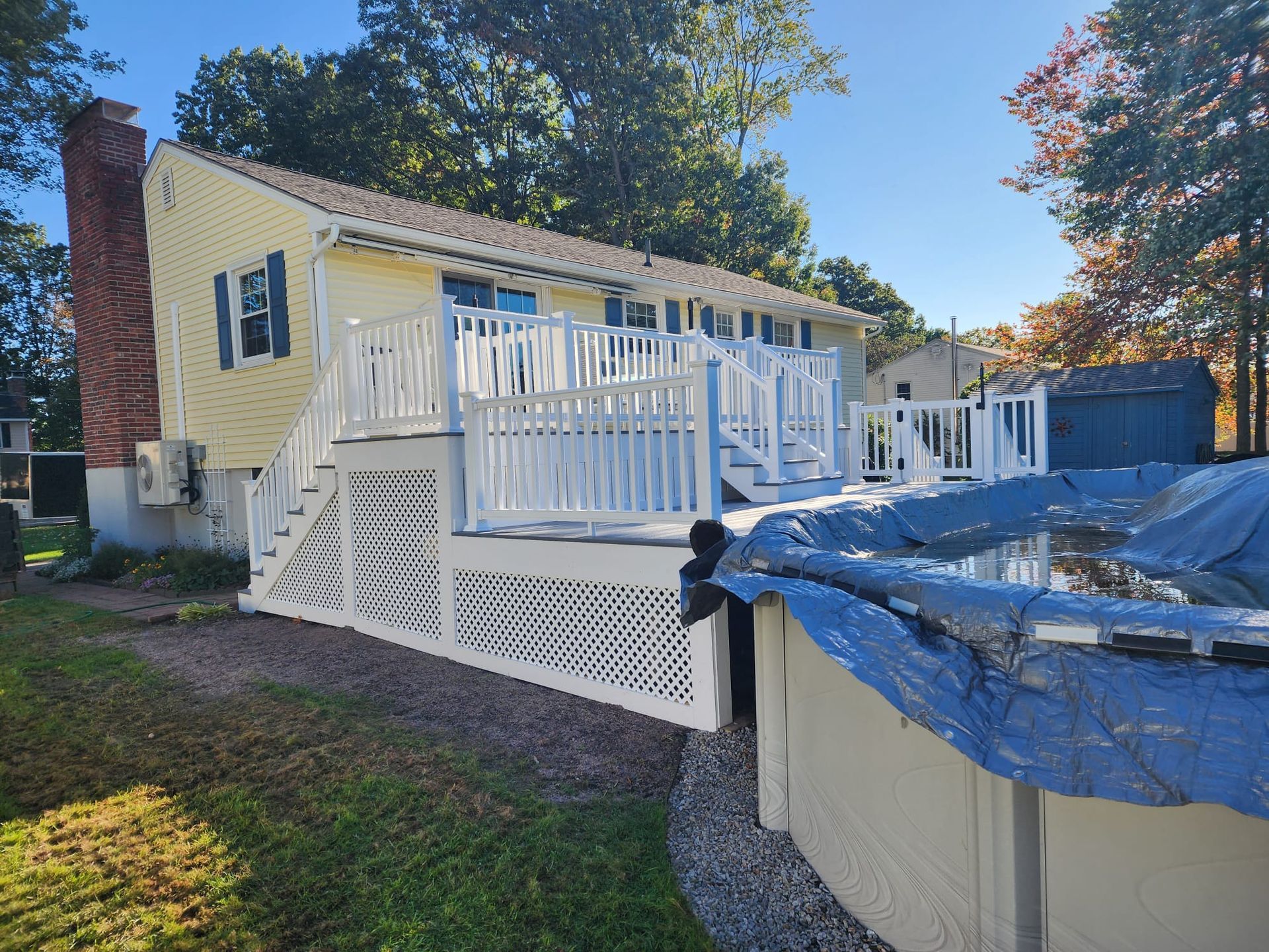A house with a large deck and a pool in front of it - Plaistow, NH - Dynamic Deck Solutions
