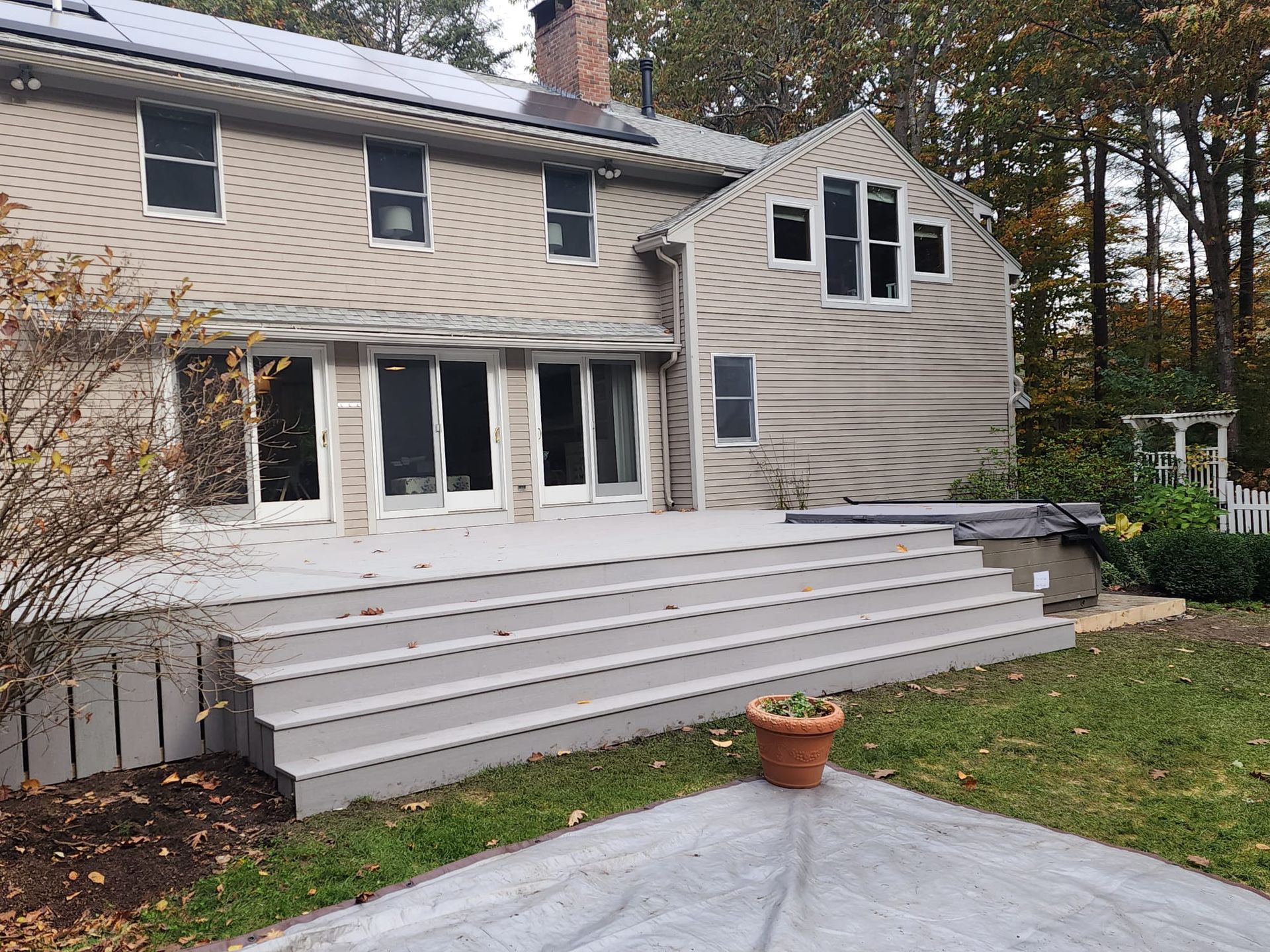 A house with a deck and stairs in front of it - Plaistow, NH - Dynamic Deck Solutions