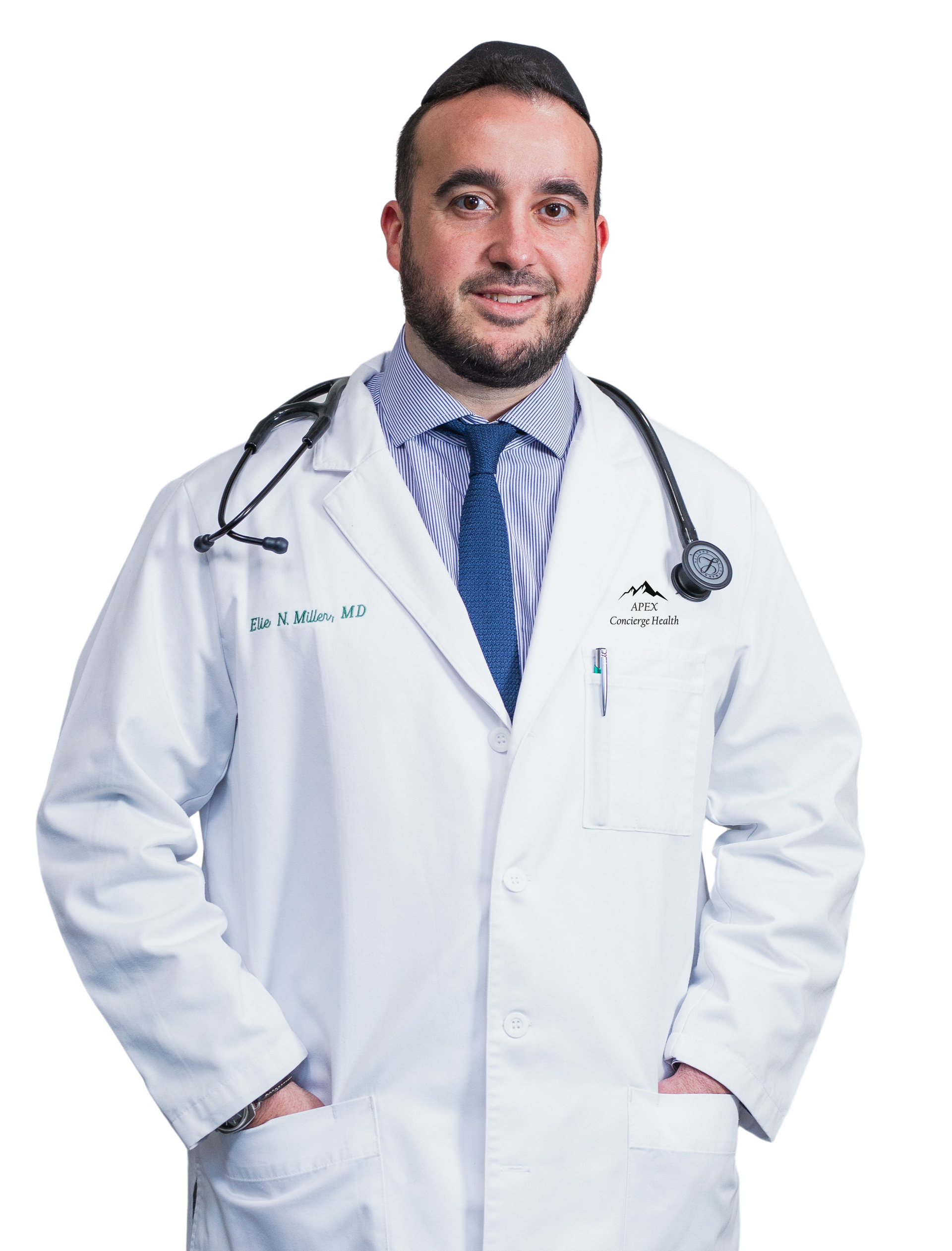 A man in a blue suit and white shirt is standing in front of trees.