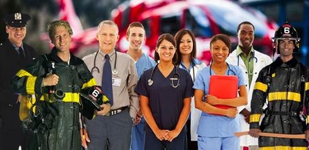 A group of people standing next to each other in front of an ambulance.
