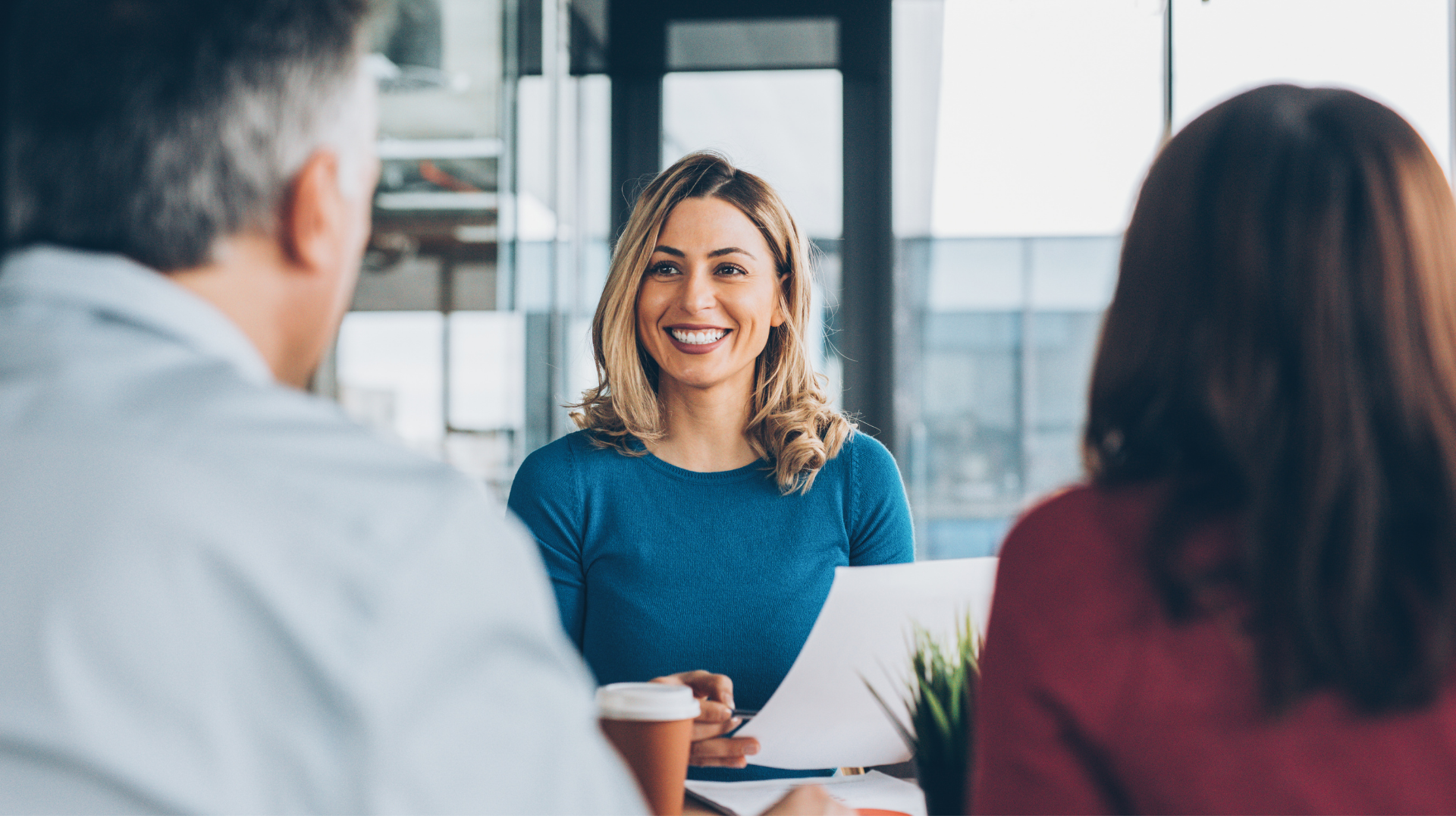 A group of people are sitting around a table having a meeting.