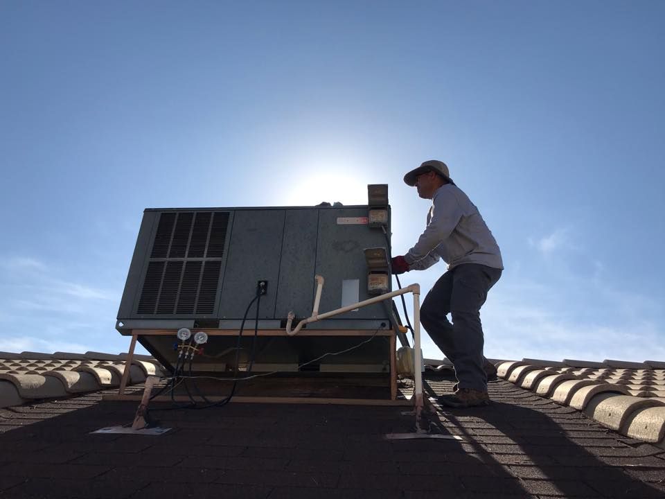 a man is working on an air conditioner on top of a roof
