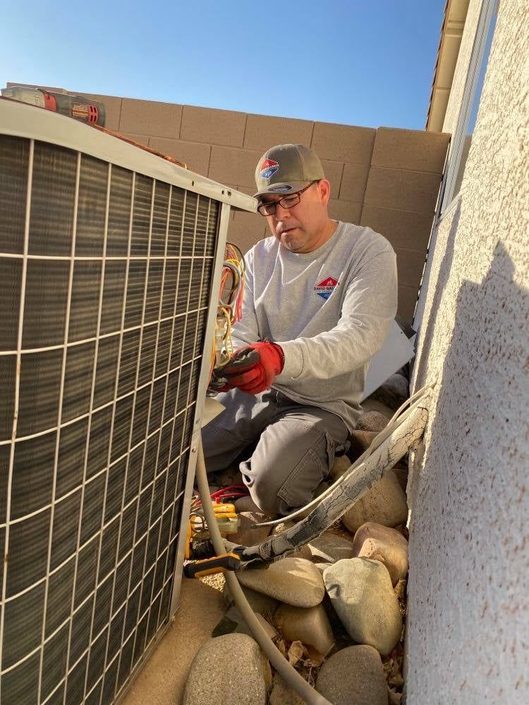 a man is working on an air conditioner outside of a building .