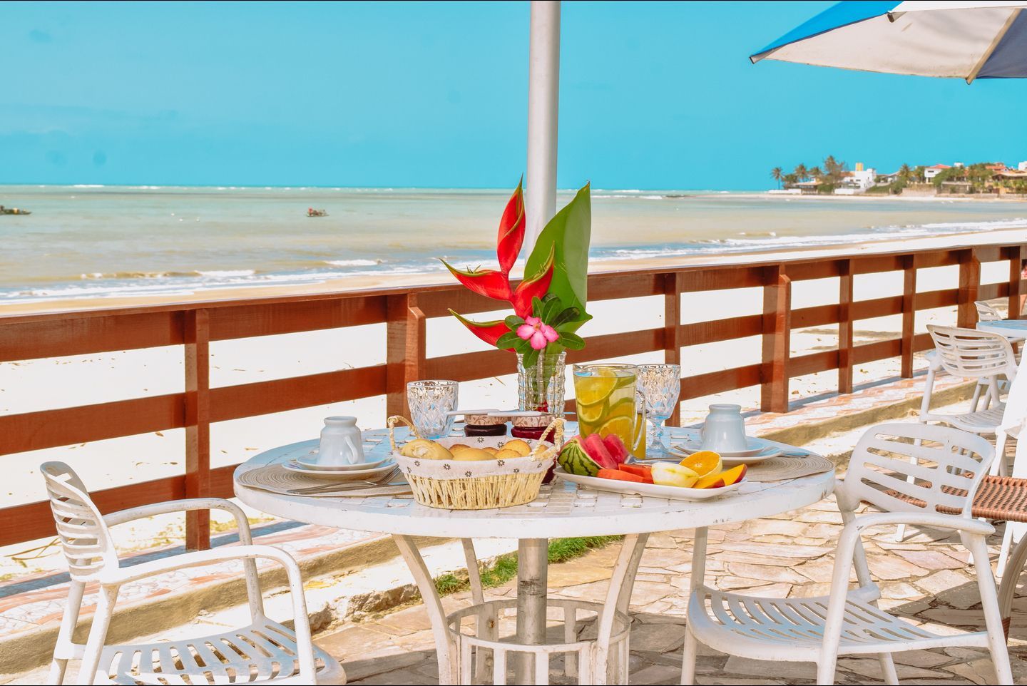 There is a table with a basket of food on it and a view of the ocean.