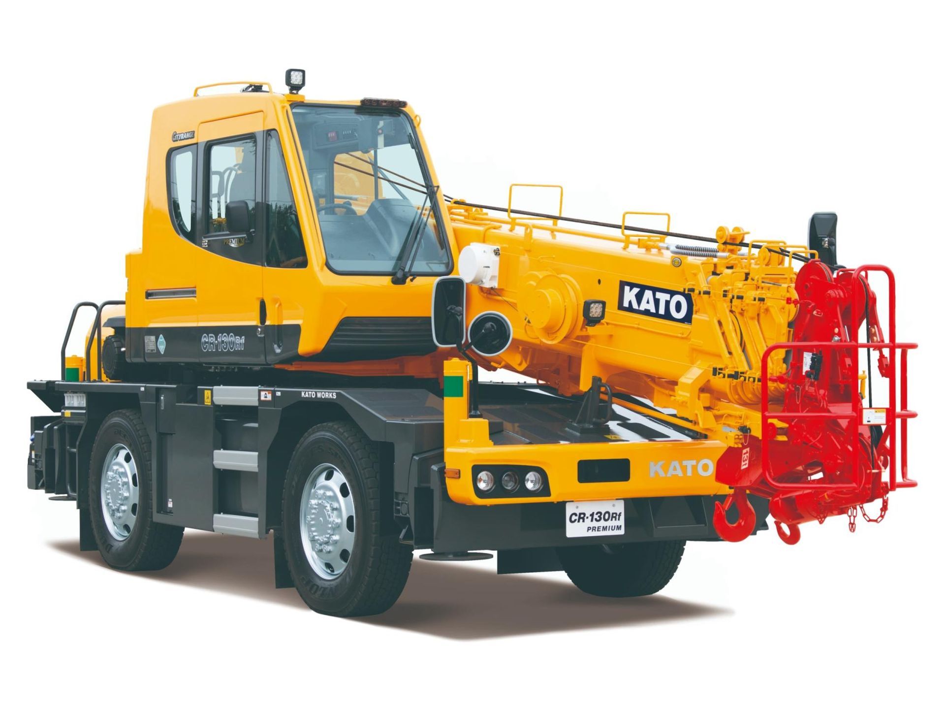 A truck with a crane attached to it is parked in front of a building.