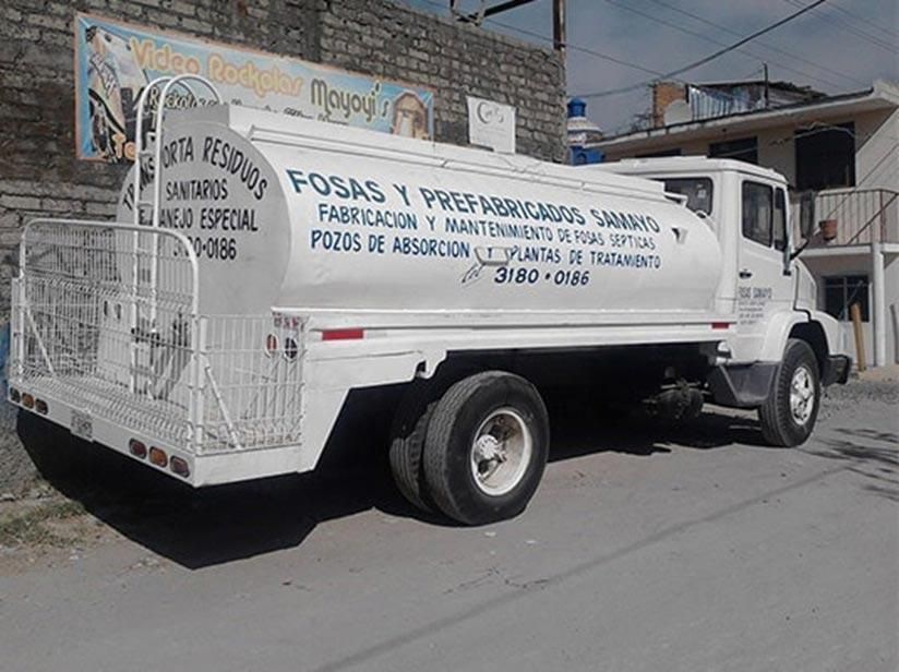 Un camión blanco está estacionado frente a un edificio de ladrillos.