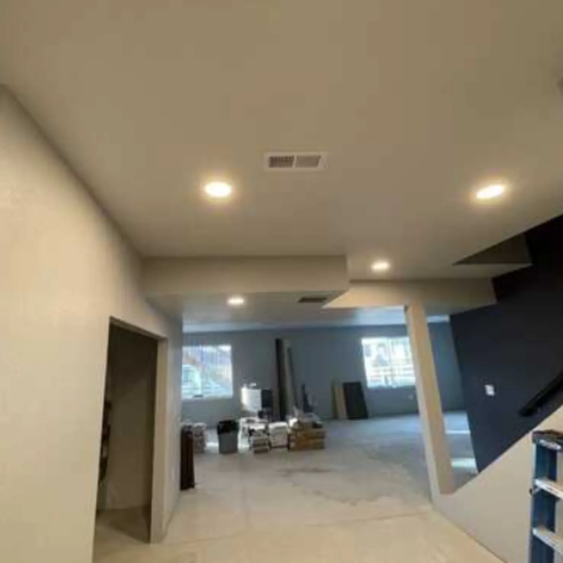 Grounded Electric - A large room with a staircase and a ceiling fan.