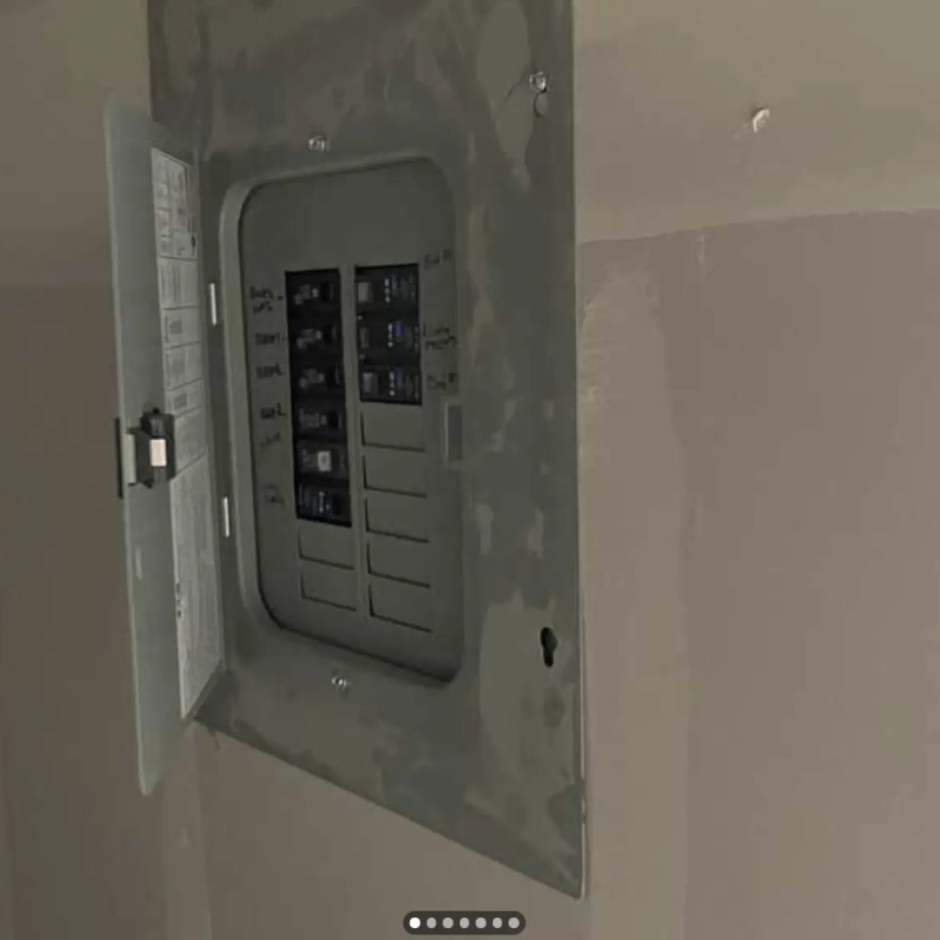 Grounded Electric - A close up of a electrical box on a wall with the door open.