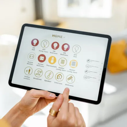 Grounded Electric - A person is holding a tablet with a home screen on it.