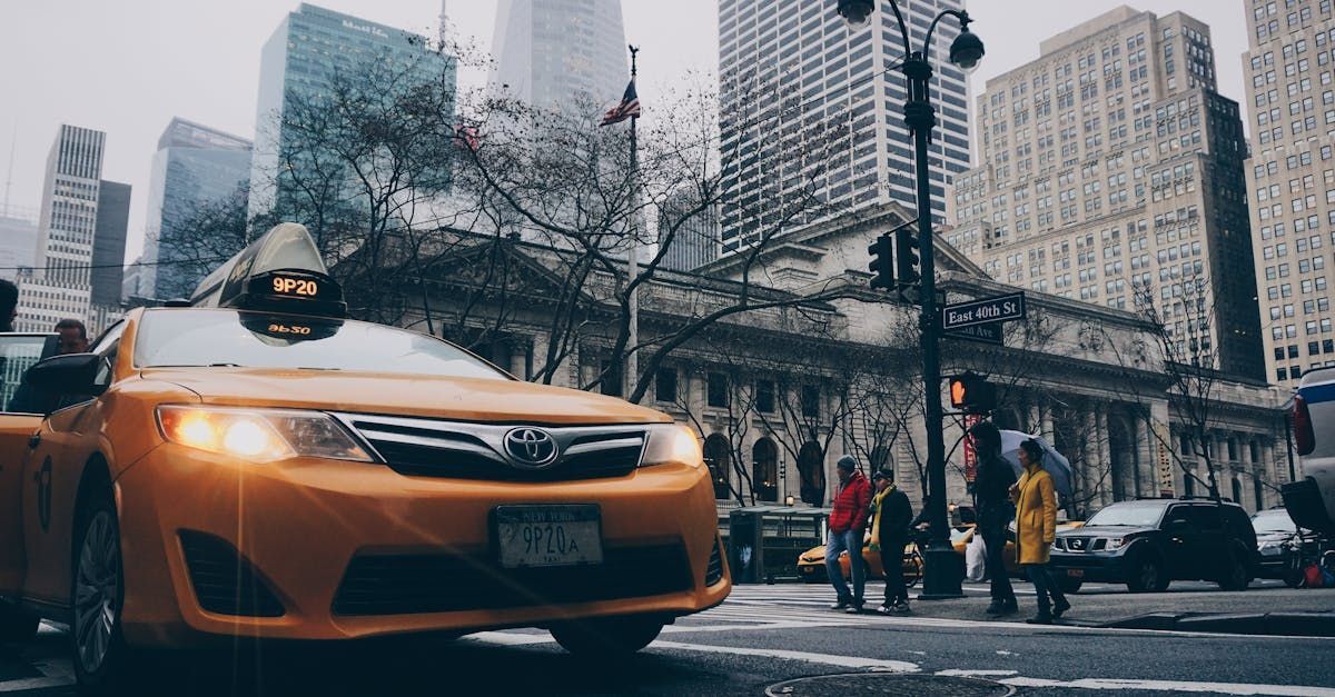 A yellow taxi is driving down a city street.