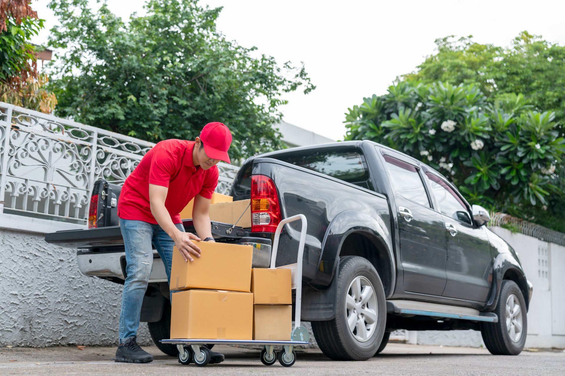 A delivery man is loading boxes into the back of a truck.