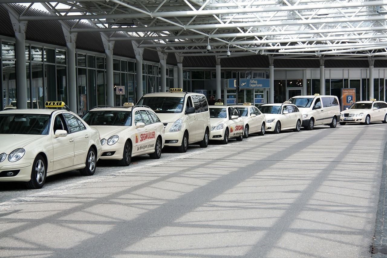 A row of taxis are parked in front of a building