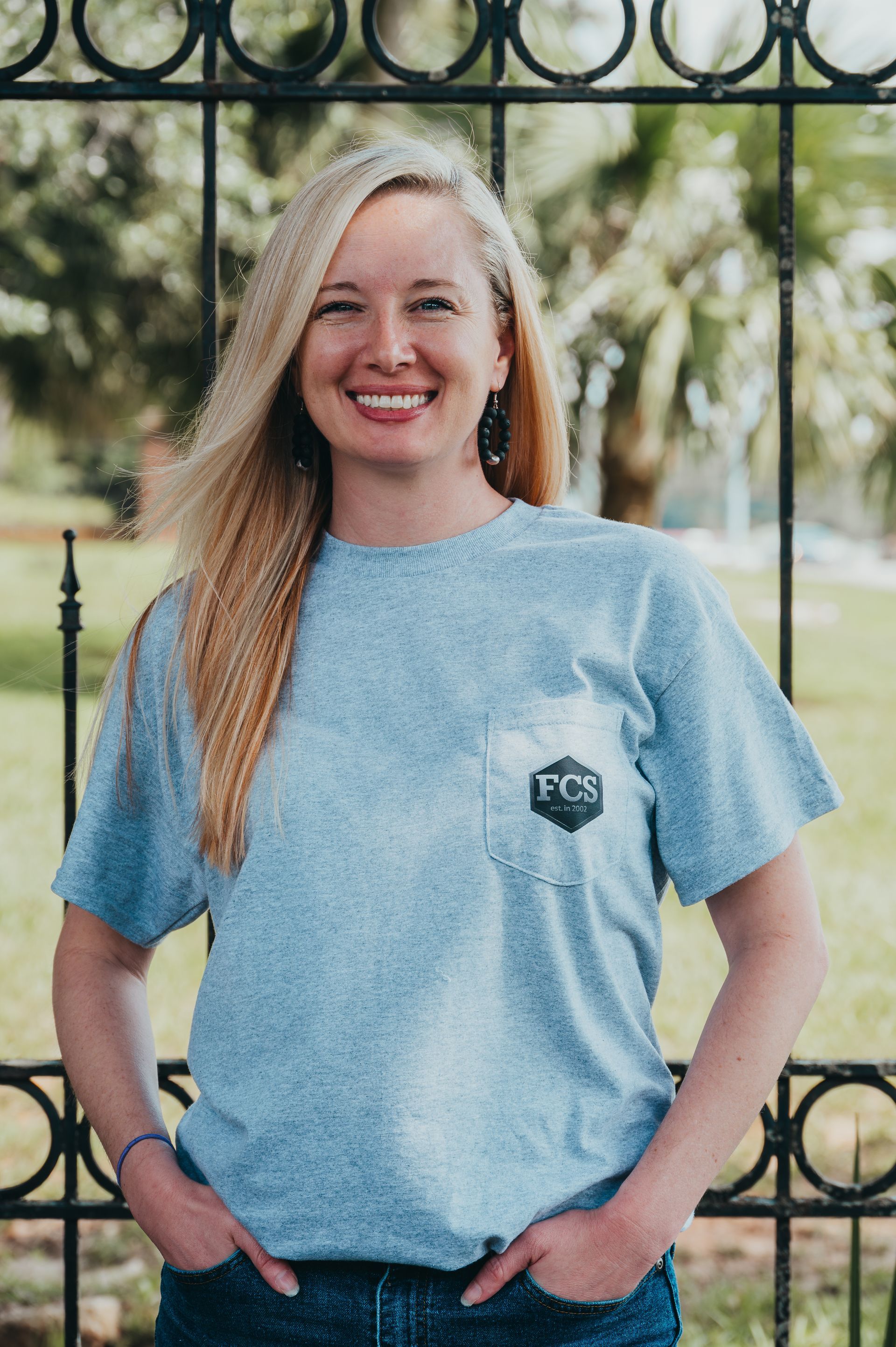 A woman wearing a grey t-shirt is smiling for the camera.